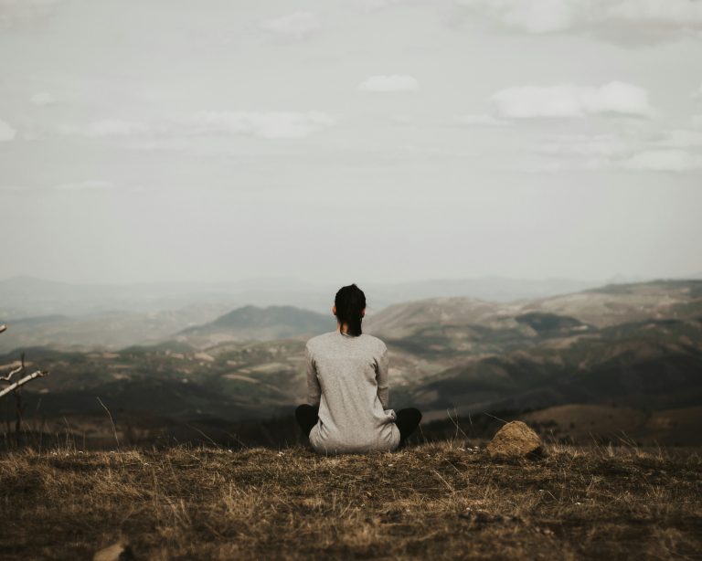 Woman looking out from mountaintop